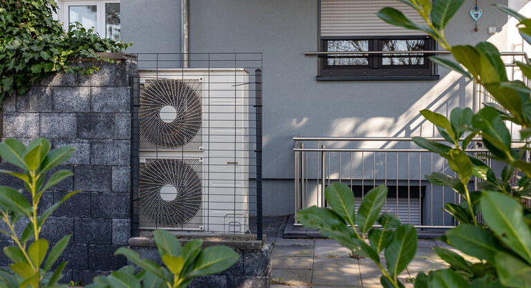 Luft-Wärmepumpen an der Gartenfront eines modernen Hauses