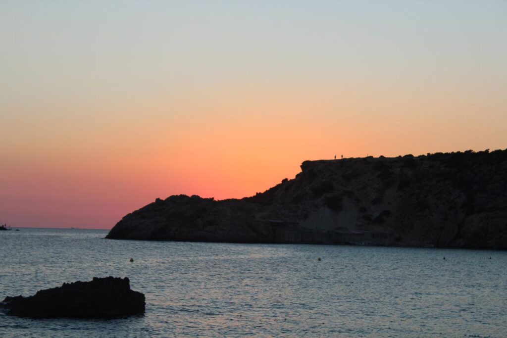 Atemberaubender Sonnenuntergang an einem Strand von Ibiza, der die romantische Atmosphäre der Insel einfängt, ideal für den Besuch von Ibiza Beach Restaurants.