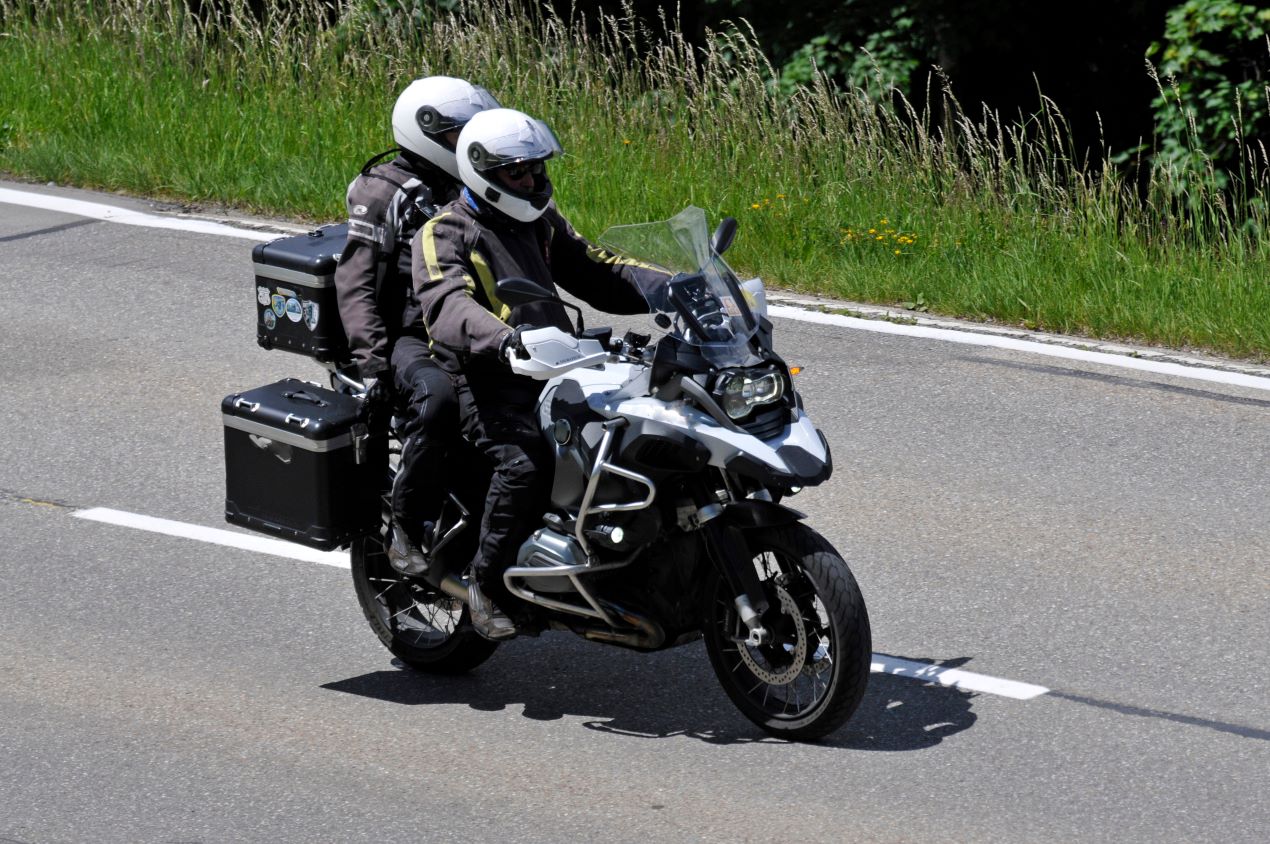 Zwei Motorradfahrer mit Schutzkleidung auf einer Landstraße, ausgestattet mit einem SW Motech Tankrucksack und robusten Gepäcksystemen