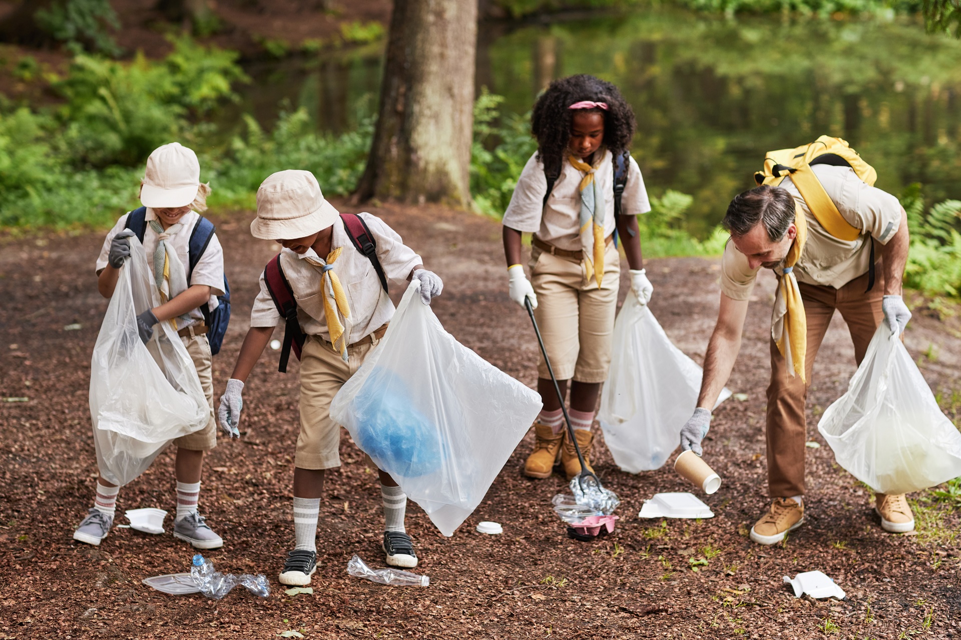 Kinder und Erwachsener sammeln Müll im Wald beim Umwelttag | Nikotinsalz Liquid